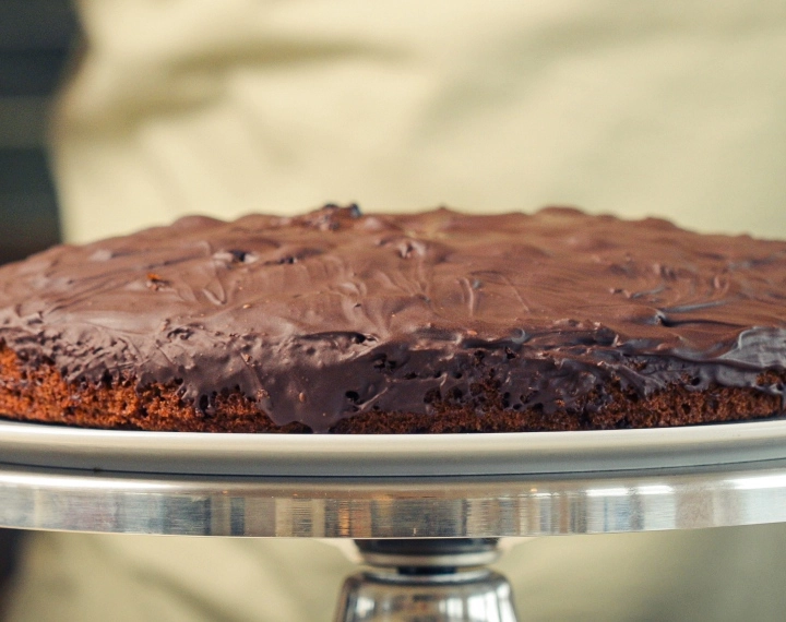 Valmis kotitekoinen cannabis space cake sulatetulla tummalla suklaalla, tarjoiltuna klassisena edible-jälkiruokana